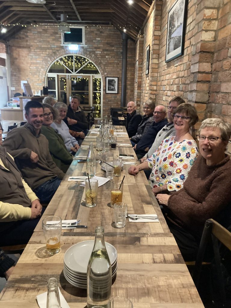 Group of people dining in rustic restaurant setting.