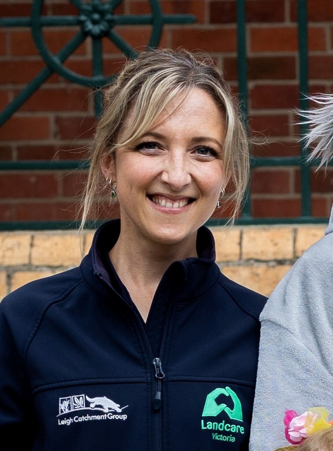 Smiling person wearing Landcare Victoria jacket outdoors.